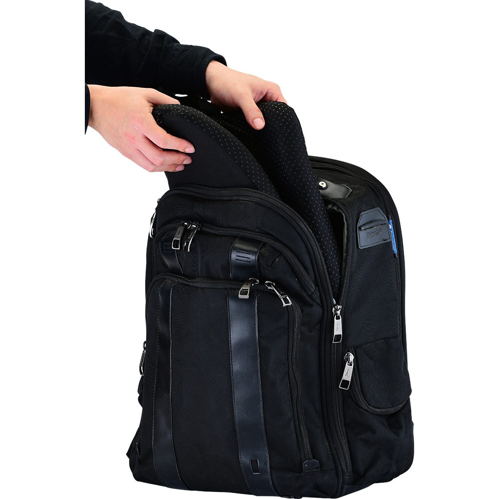 Hands inserting laptop sleeve into black backpack